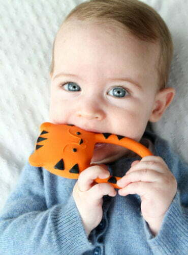 Baby met bijtspeeltje van natuurlijk rubber in de vorm van een tijger in de mond